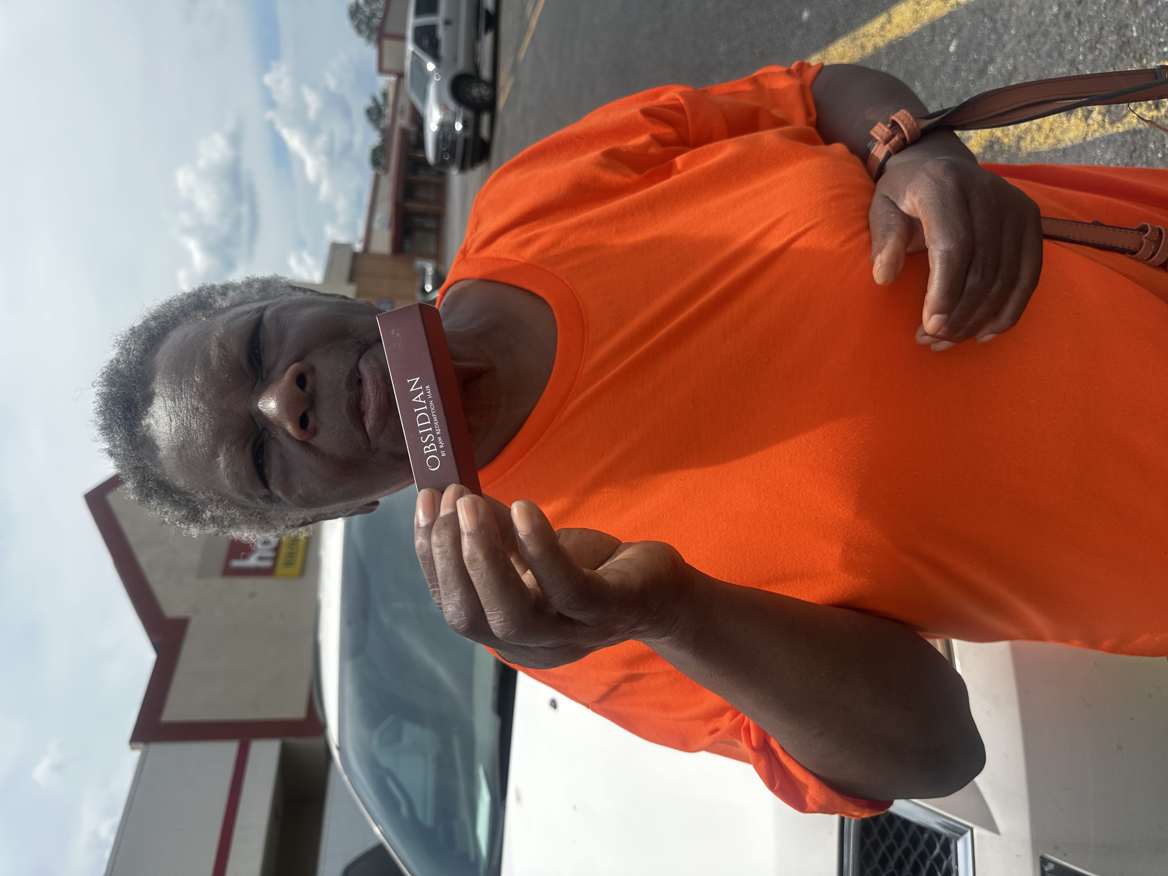 Supporter holding Obsidian Lip Oil outdoors
