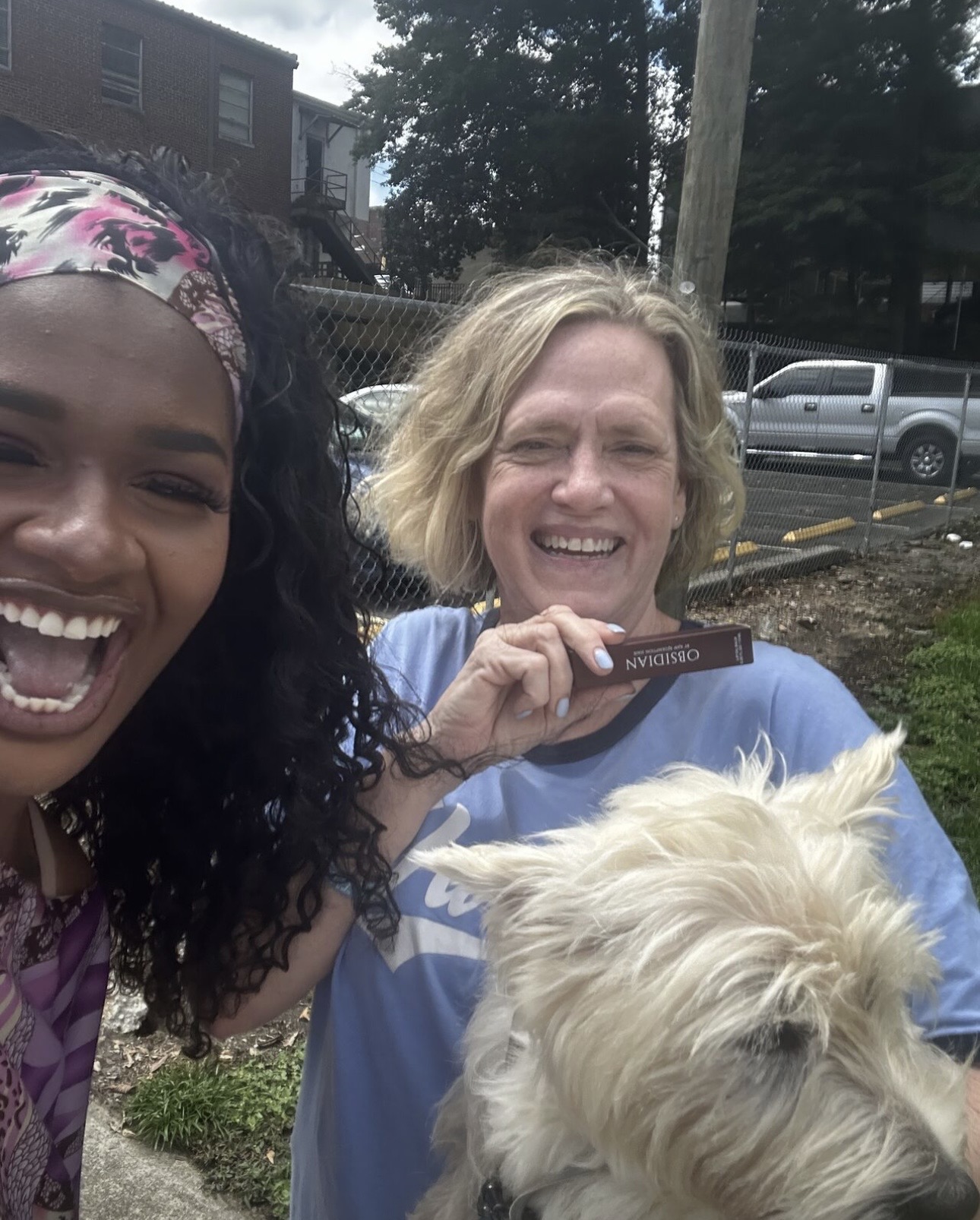 Supporter showing off Obsidian Lip Oil with a friend and her dog